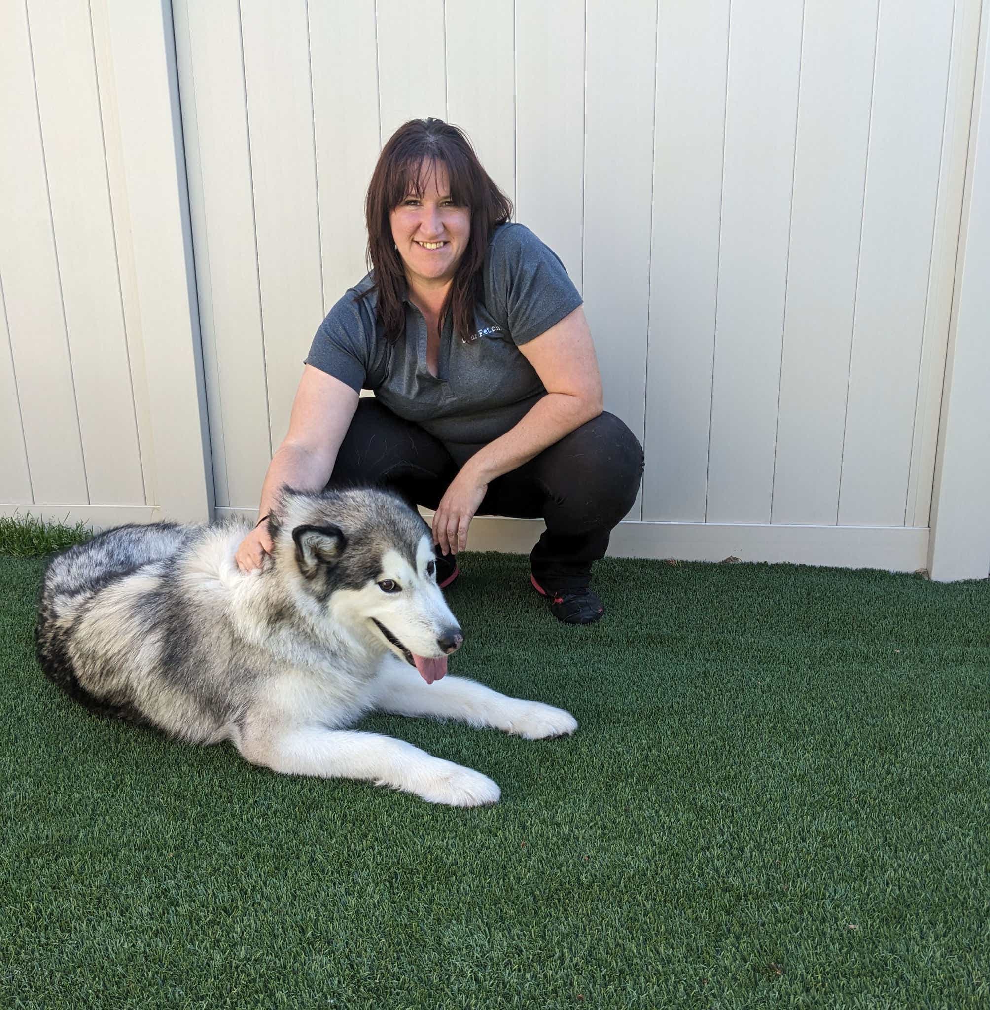 woman-staff-hugging-dogs-sitting-smiling